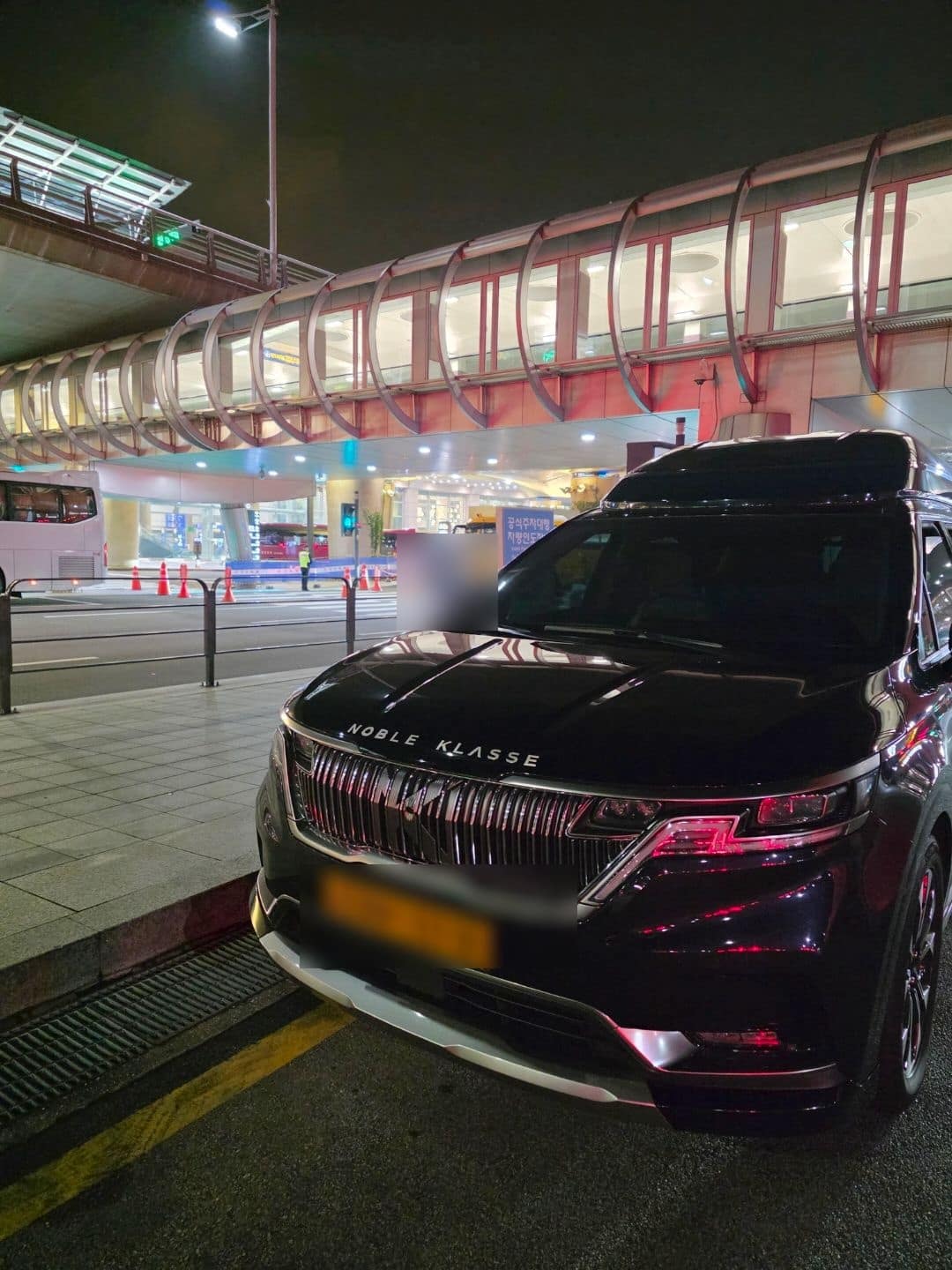 공항 터미널 승하차장에서 대기 중인 더블랙 모빌리티 카니발 하이리무진 의전 차량